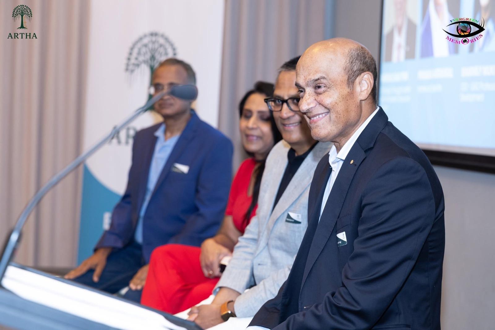 Artha co-founders seated on the panel at the Soft Launch Event, with the Artha banner behind them.