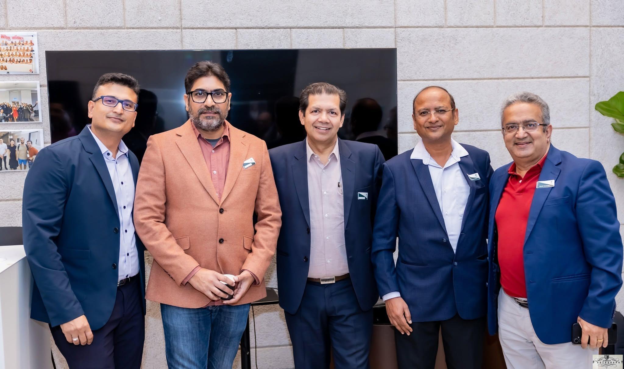 Five members standing in front of the presentation screen at an Artha event