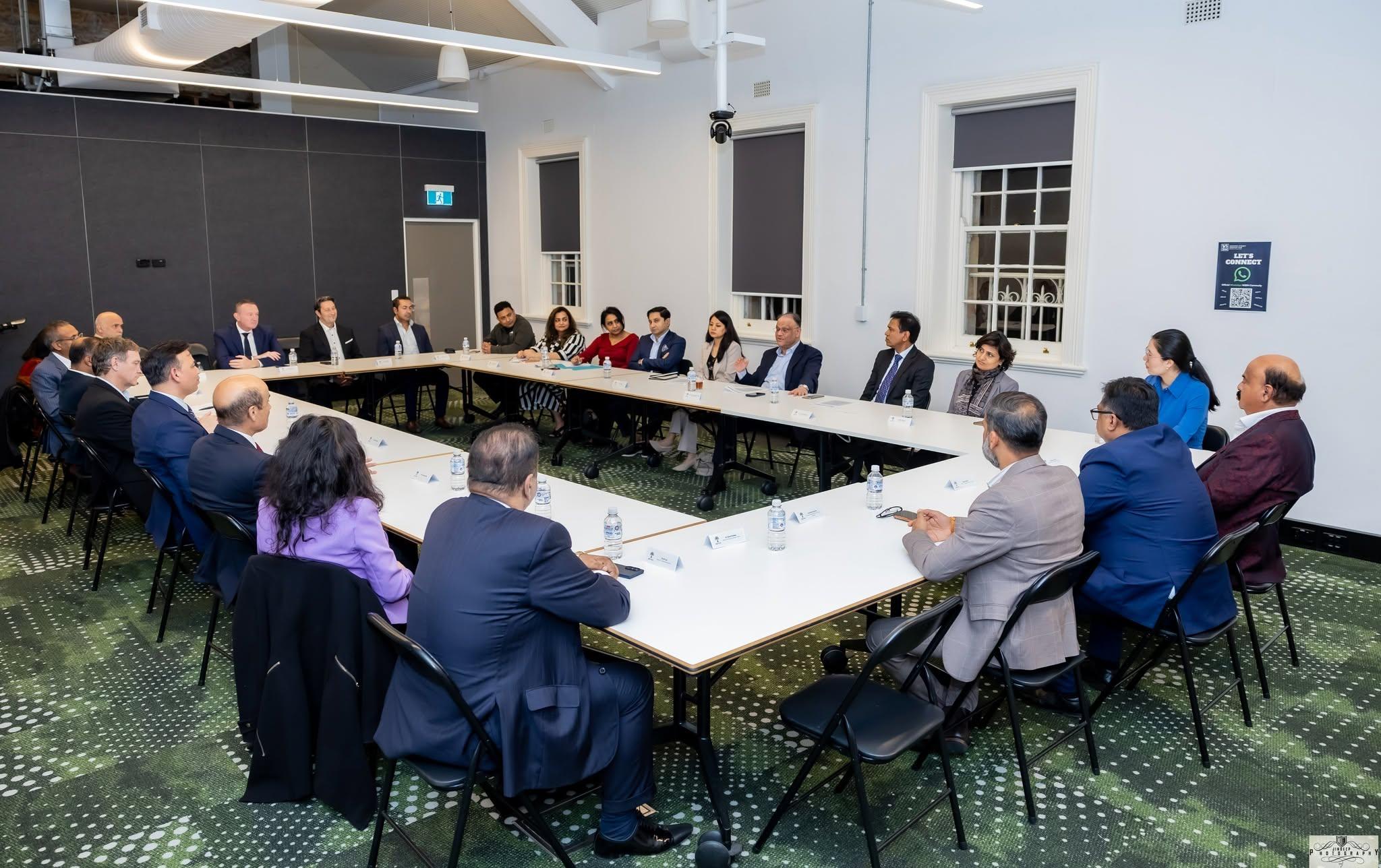 Artha members and mentors seated around the boardroom table at a roundtable meeting.